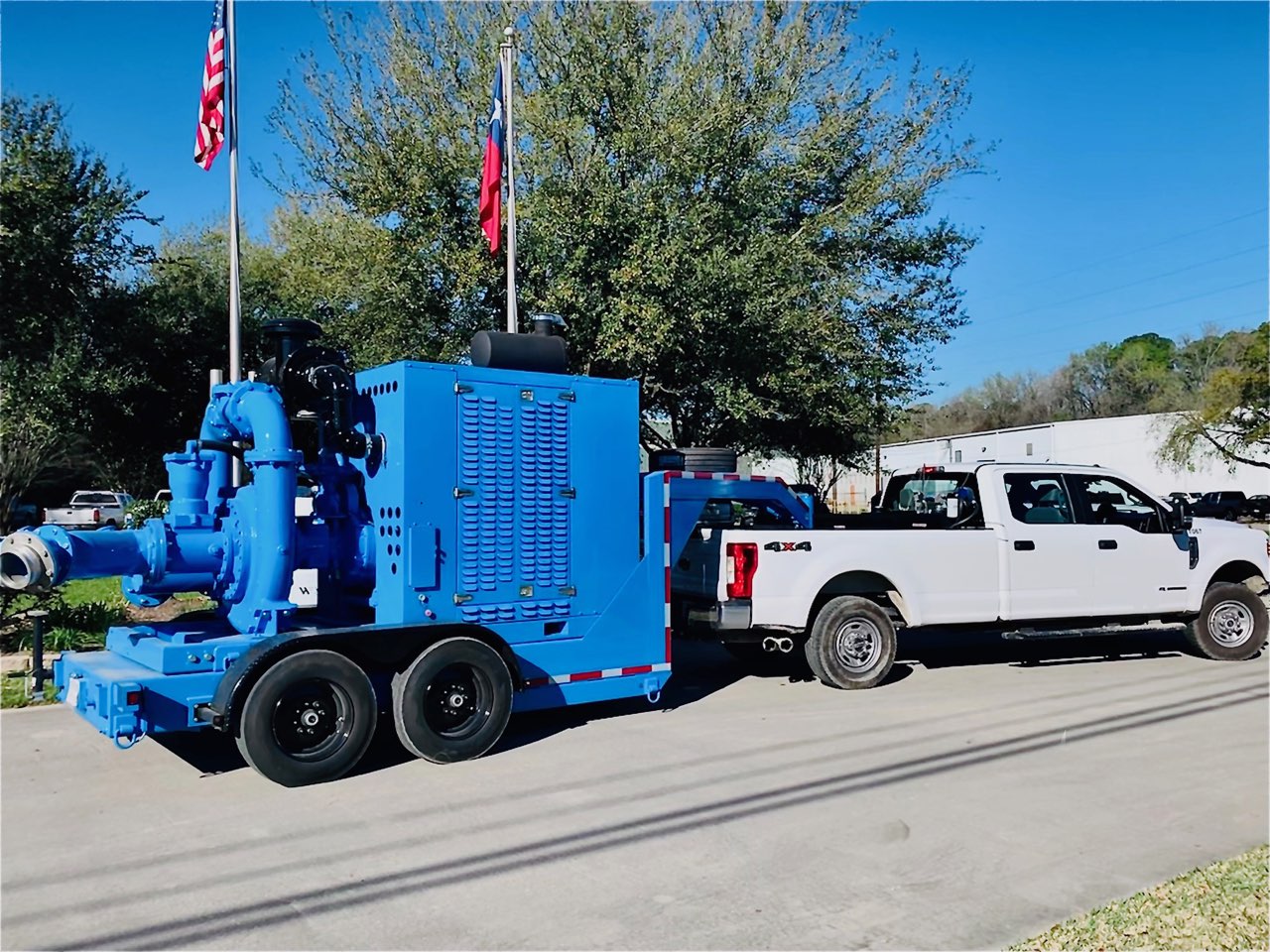 Truck hauling large blue pump